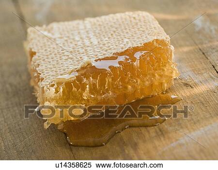 Stock Photography - Close up of honeycomb dripping honey. Fotosearch