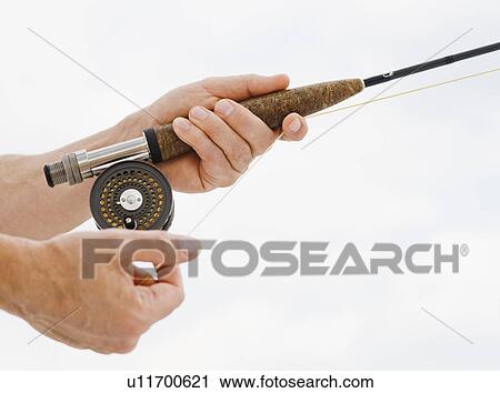 Stock Image - Close up of man fishing rod. Fotosearch