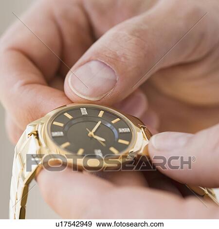 Close up of man winding watch View Large Photo Image Stock Photo - Close up of man winding watch. Fotosearch