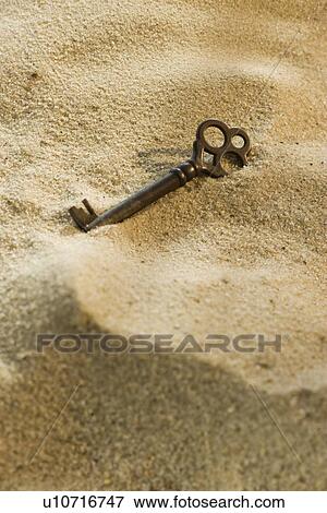 Close up of old-fashioned key in sand View Large Photo Image Stock Photo - Close up of old-fashioned key in sand. Fotosearch
