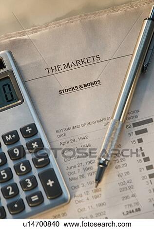 Stock Image - Close up of pen, calculator and financial pages. Fotosearch