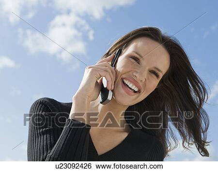 Close up of smiling woman talking on cell phone View Large Photo Image Stock Photograph - Close up of smiling woman talking on cell phone. Fotosearch
