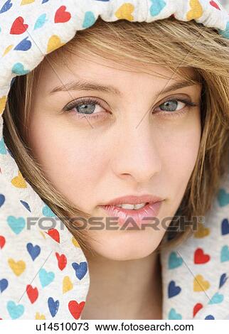 Stock Image - Close up of woman wearing hood. Fotosearch
