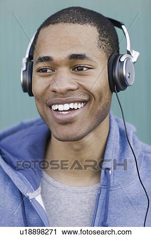 Close up of young man listening to headphones View Large Photo Image Stock Image - Close up of young man listening to headphones. Fotosearch
