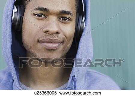 Stock Photography - Close up portrait of young man listening to headphones. Fotosearch