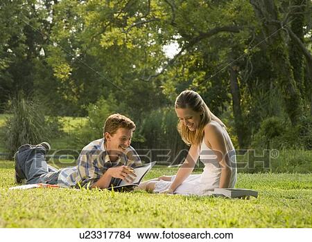 Picture - College students studying in grass. Fotosearch