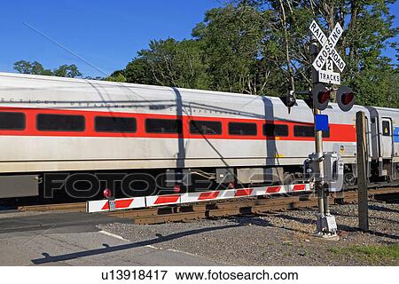 Stock Photo - Commuter train and road crossing. Fotosearch