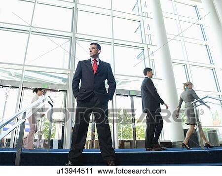 Confident businessman posing in lobby View Large Photo Image Stock Image - Confident businessman posing in lobby. Fotosearch