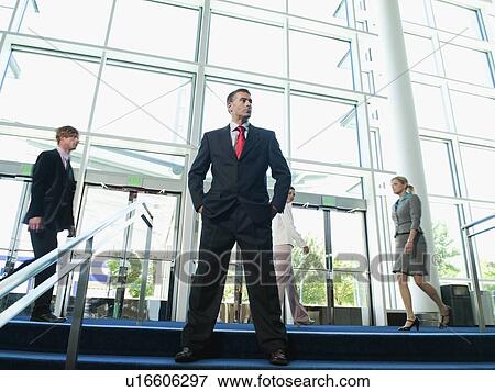 Stock Photo - Confident businessman posing in lobby. Fotosearch