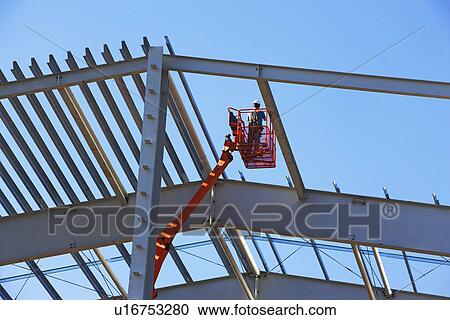 Stock Image - Construction worker in cherry picker. Fotosearch