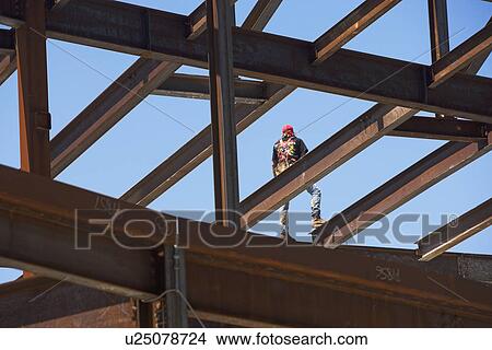 Construction worker on steel beam at construction site View Large Photo Image Picture - Construction worker on steel beam at construction site. Fotosearch