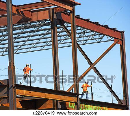 Stock Photo - Construction workers walking on steel girders, New York City, New York, United States. Fotosearch