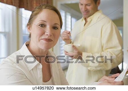 Stock Image - Couple beginning day in kitchen. Fotosearch