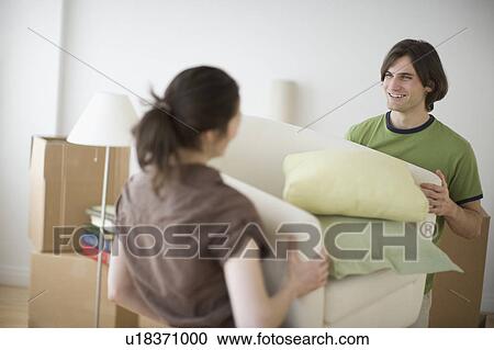 Couple carrying bedding in new house View Large Photo Image Stock Image - Couple carrying bedding in new house. Fotosearch
