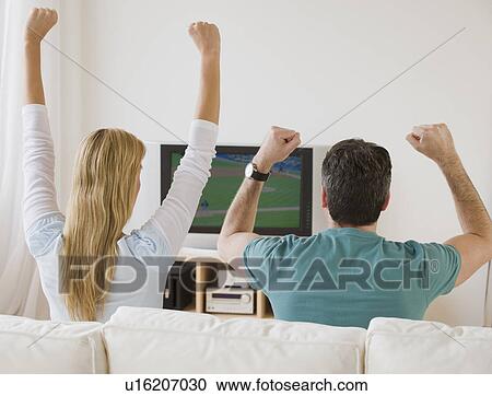 Couple cheering at television View Large Photo Image Stock Image - Couple cheering at television . Fotosearch