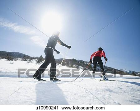Stock Image - Couple cross country skiing. Fotosearch