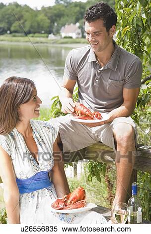 Stock Photography - Couple eating lobster on deck. Fotosearch