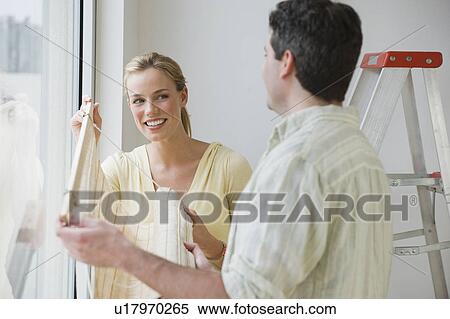Couple hanging window blinds View Large Photo Image Stock Photography - Couple hanging window blinds. Fotosearch
