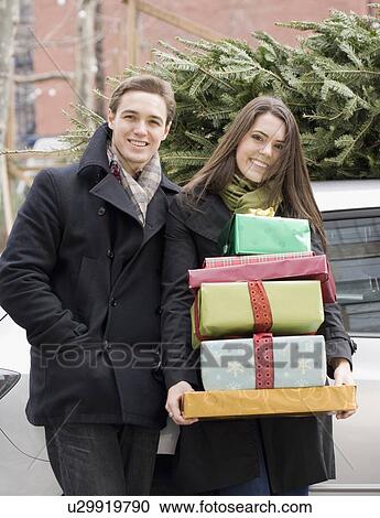 Couple holding stack of Christmas gifts View Large Photo Image Stock Image - Couple holding stack of Christmas gifts. Fotosearch