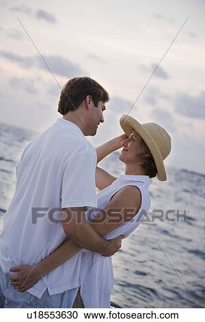 Couple hugging in front of water View Large Photo Image Stock Image - Couple hugging in front of water. Fotosearch