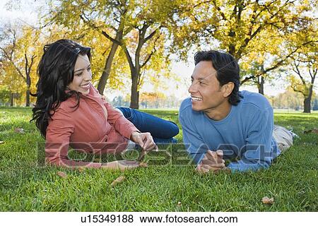 Couple laying in grass View Large Photo Image Stock Photo - Couple laying in grass. Fotosearch