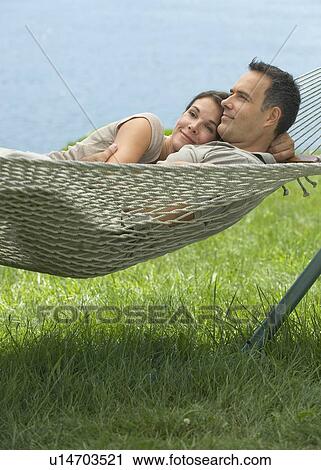 Stock Image - Couple laying in hammock. Fotosearch