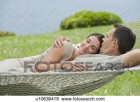 Couple laying in hammock View Large Photo Image Stock Photo - Couple laying in hammock. Fotosearch