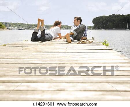Couple laying on dock View Large Photo Image Stock Image - Couple laying on dock. Fotosearch
