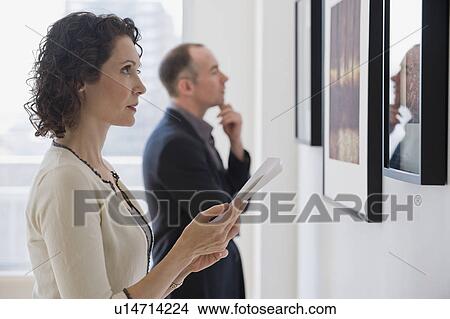Picture - Couple looking at art in art gallery. Fotosearch