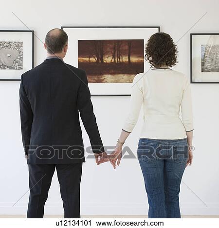 Stock Image - Couple looking at art in art gallery. Fotosearch
