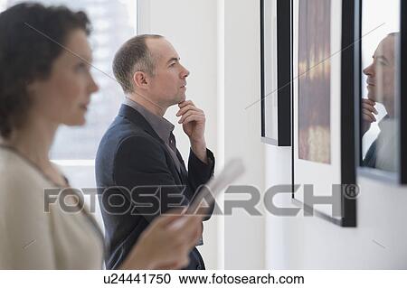 Couple looking at art in art gallery View Large Photo Image Stock Image - Couple looking at art in art gallery. Fotosearch