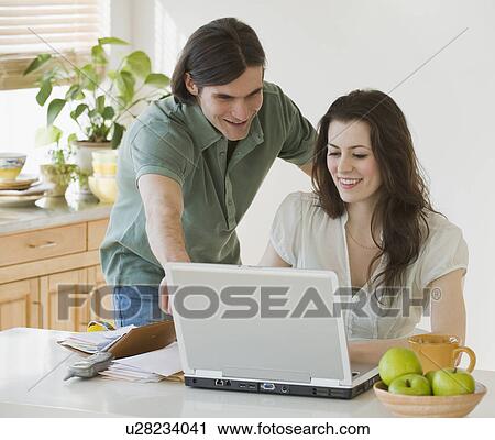 Couple looking at laptop View Large Photo Image Stock Image - Couple looking at laptop. Fotosearch