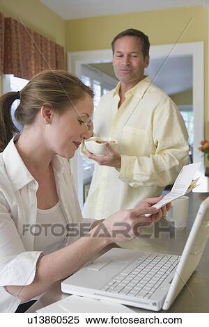 Couple paying bills in kitchen View Large Photo Image Stock Photography - Couple paying bills in kitchen. Fotosearch