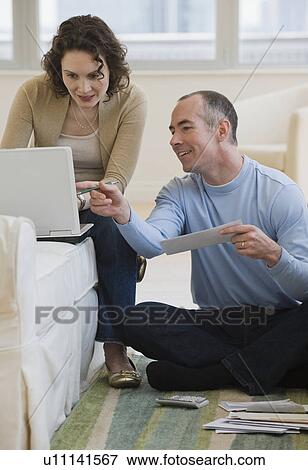 Couple paying bills online at home View Large Photo Image Stock Photo - Couple paying bills online at home. Fotosearch