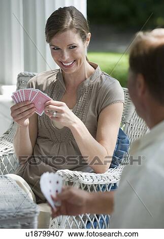 Stock Photo - Couple playing card game on porch. Fotosearch