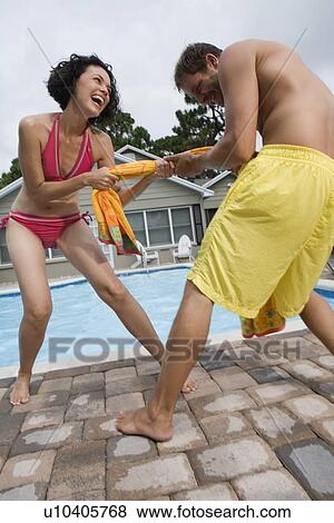 Stock Photo - Couple playing tug-of-war with towel. Fotosearch