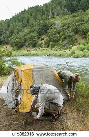 Couple preparing campsite View Large Photo Image Stock Photograph - Couple preparing campsite. Fotosearch