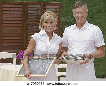 Couple preparing outdoor restaurant for service View Large Photo Image Stock Image - Couple preparing outdoor restaurant for service. Fotosearch
