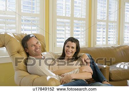 Stock Image - Couple relaxing in livingroom. Fotosearch