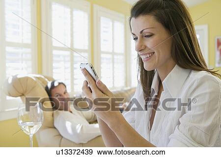 Stock Photo - Couple relaxing in livingroom. Fotosearch