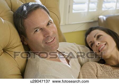 Couple relaxing in livingroom View Large Photo Image Stock Photo - Couple relaxing in livingroom. Fotosearch