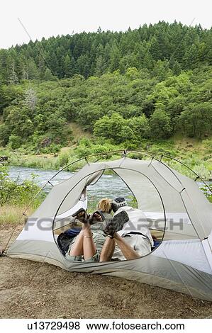 Couple relaxing in tent View Large Photo Image Stock Photo - Couple relaxing in tent. Fotosearch