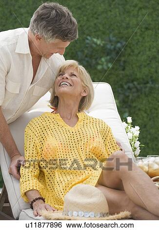 Couple relaxing on patio View Large Photo Image Stock Photograph - Couple relaxing on patio. Fotosearch