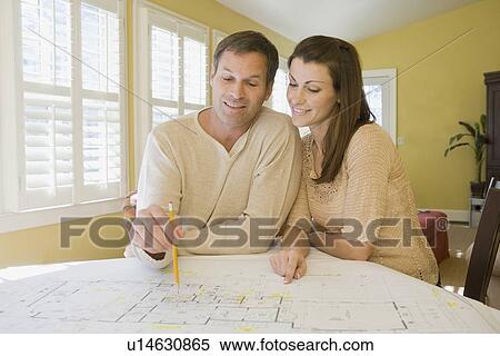 Couple reviewing house blueprints View Large Photo Image Stock Photography - Couple reviewing house blueprints. Fotosearch