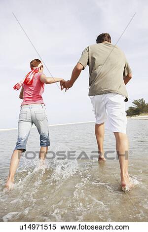 Couple running in ocean View Large Photo Image Stock Photography - Couple running in ocean. Fotosearch