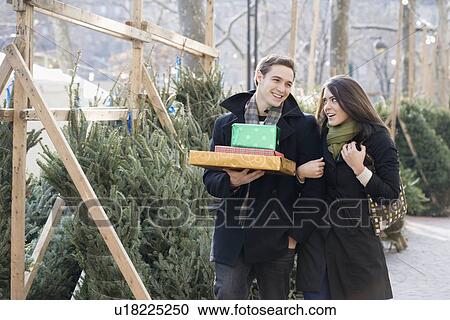 Stock Image - Couple shopping for Christmas trees. Fotosearch