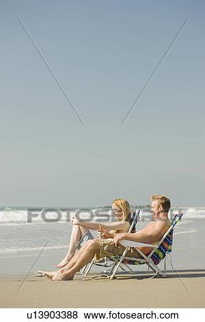 Couple sitting in beach chairs View Large Photo Image Stock Photo - Couple sitting in beach chairs. Fotosearch