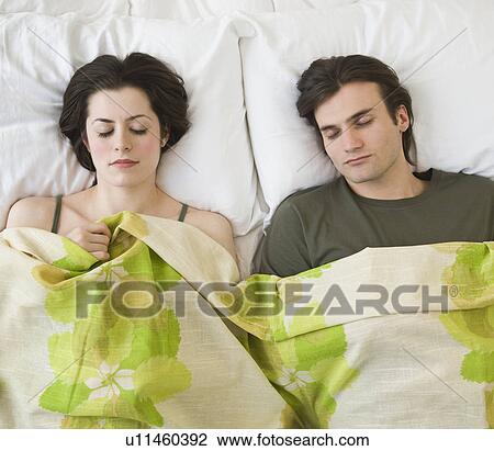 Stock Image - Couple sleeping in bed. Fotosearch