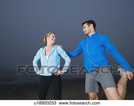 Couple stretching on beach View Large Photo Image Stock Image - Couple stretching on beach. Fotosearch