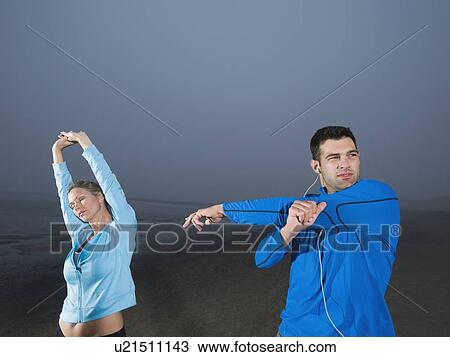 Couple stretching on beach View Large Photo Image Stock Image - Couple stretching on beach. Fotosearch